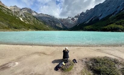 Persona sentada frente a la Laguna Esmeralda en Ushuaia, disfrutando de la tranquilidad y la vista panorámica sin turistas al llegar temprano con XPLOR TURISMO