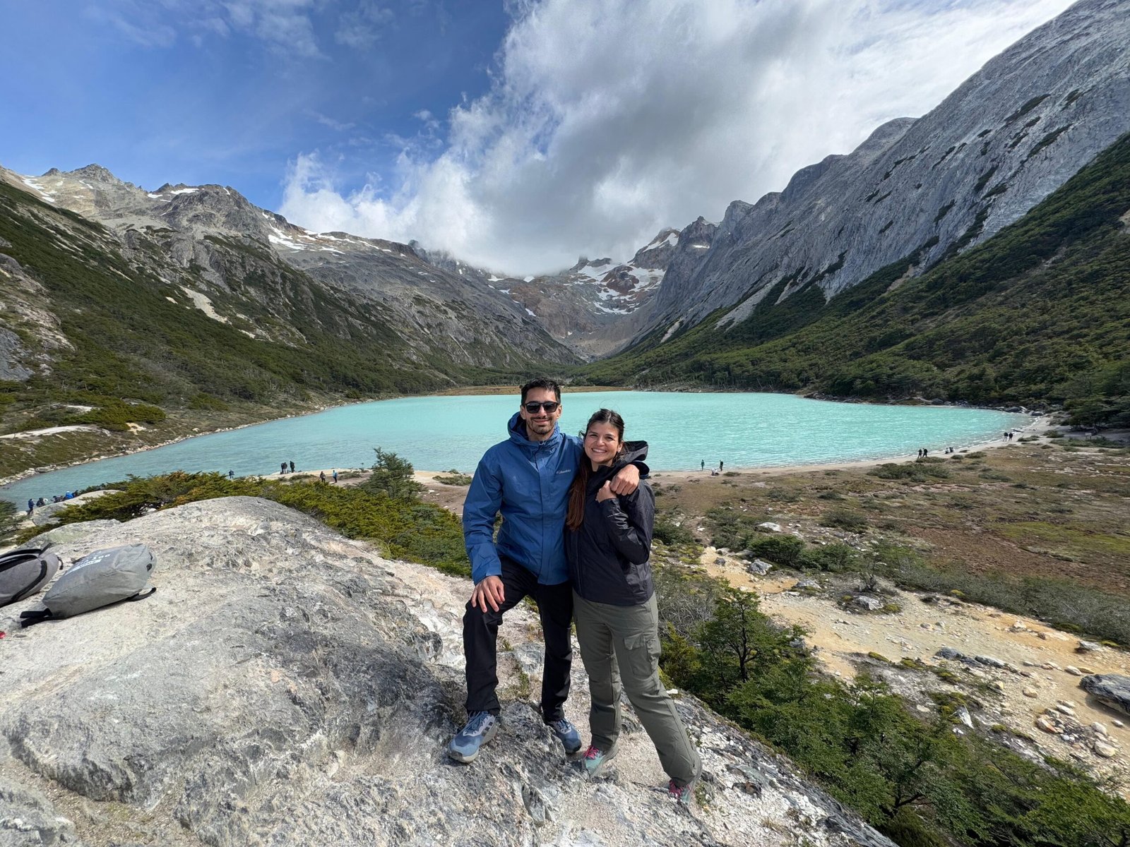 Pareja disfrutando de la Laguna Esmeralda en Ushuaia, rodeados de montañas y naturaleza, en una excursión con XPLOR TURISMO