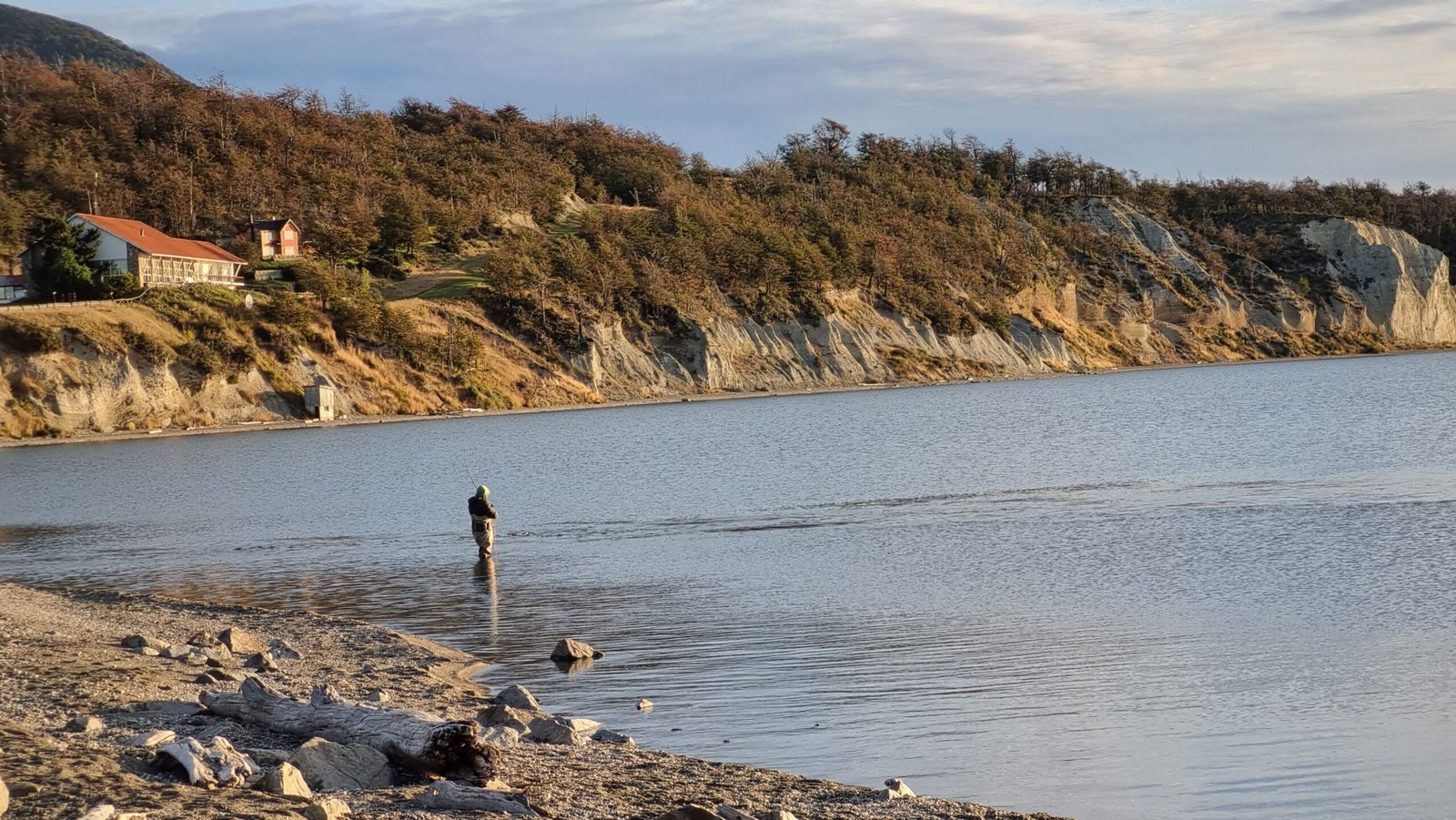 Pescador en la cabecera del Lago Fagnano, Tolhuin, lanzando su línea en busca de truchas en un entorno natural patagónico.