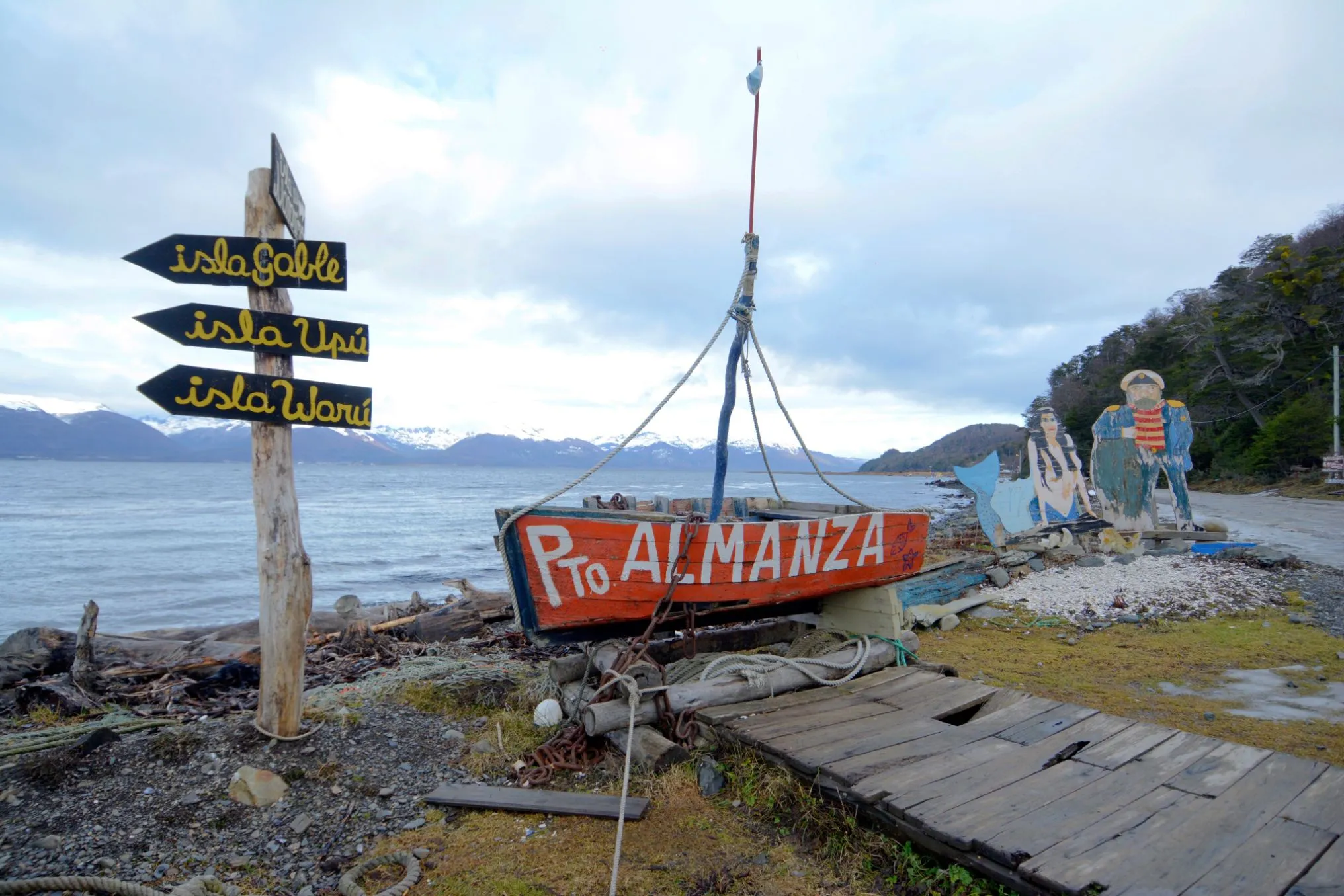 Cartel de bienvenida artesanal en Puerto Almanza con vista al Canal Beagle e islas cercanas.