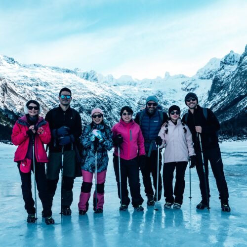 Grupo de turistas posando sobre la superficie congelada de Laguna Esmeralda junto a VERTICE EXPEDICIONES.
