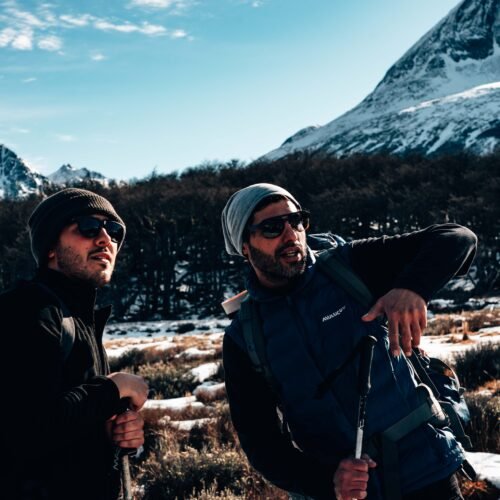 Marcelo Vaca Guía de trekking de VERTICE señalando el camino entre montañas nevadas hacia Laguna Esmeralda