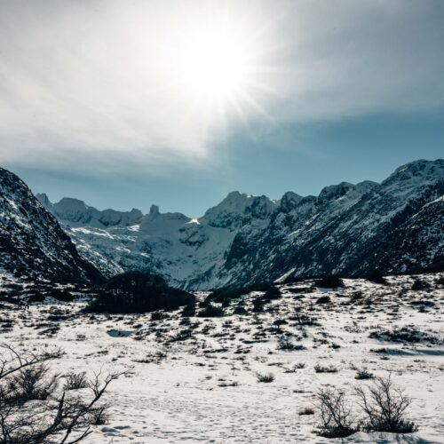 Panorámica del valle de turbera cubierto de nieve bajo el sol hacia Laguna Esmeralda con VERTICE EXPEDICIONES.